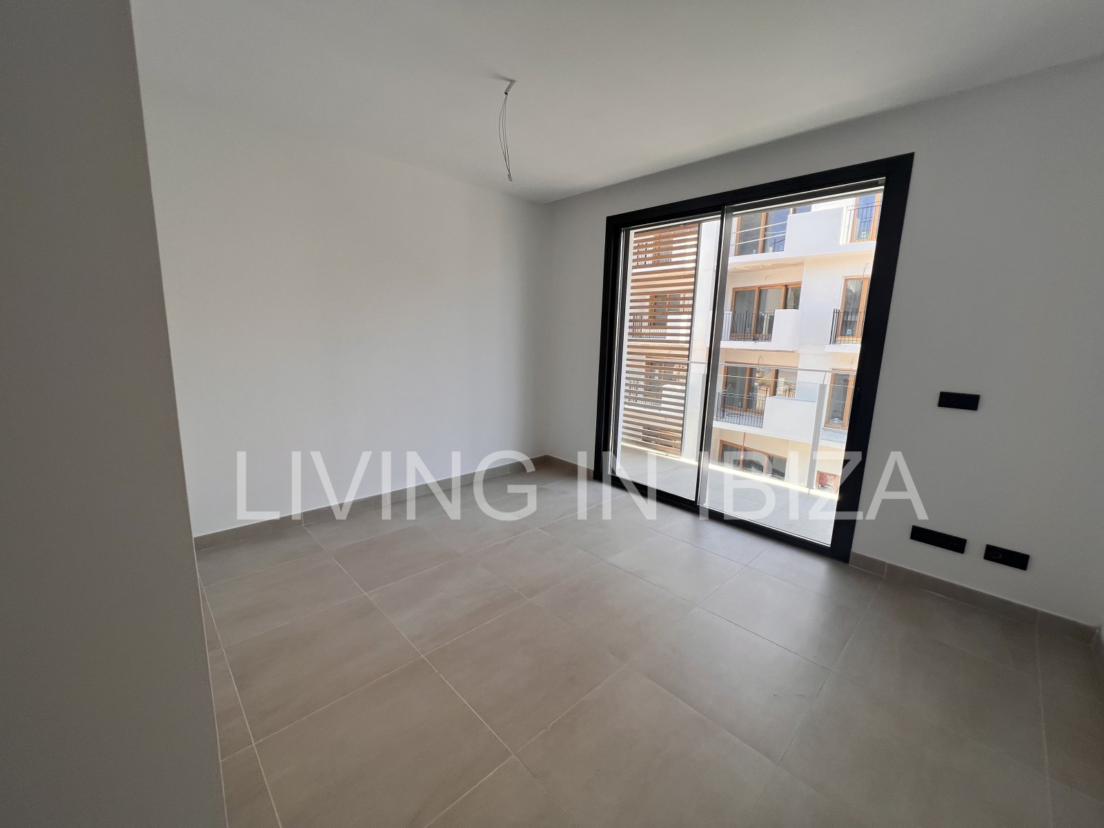 Annual rental. Available 15th July. Attractive and modern new unfurnished flat, with communal pool, parking, in Santa Eulalia, Ibiza.