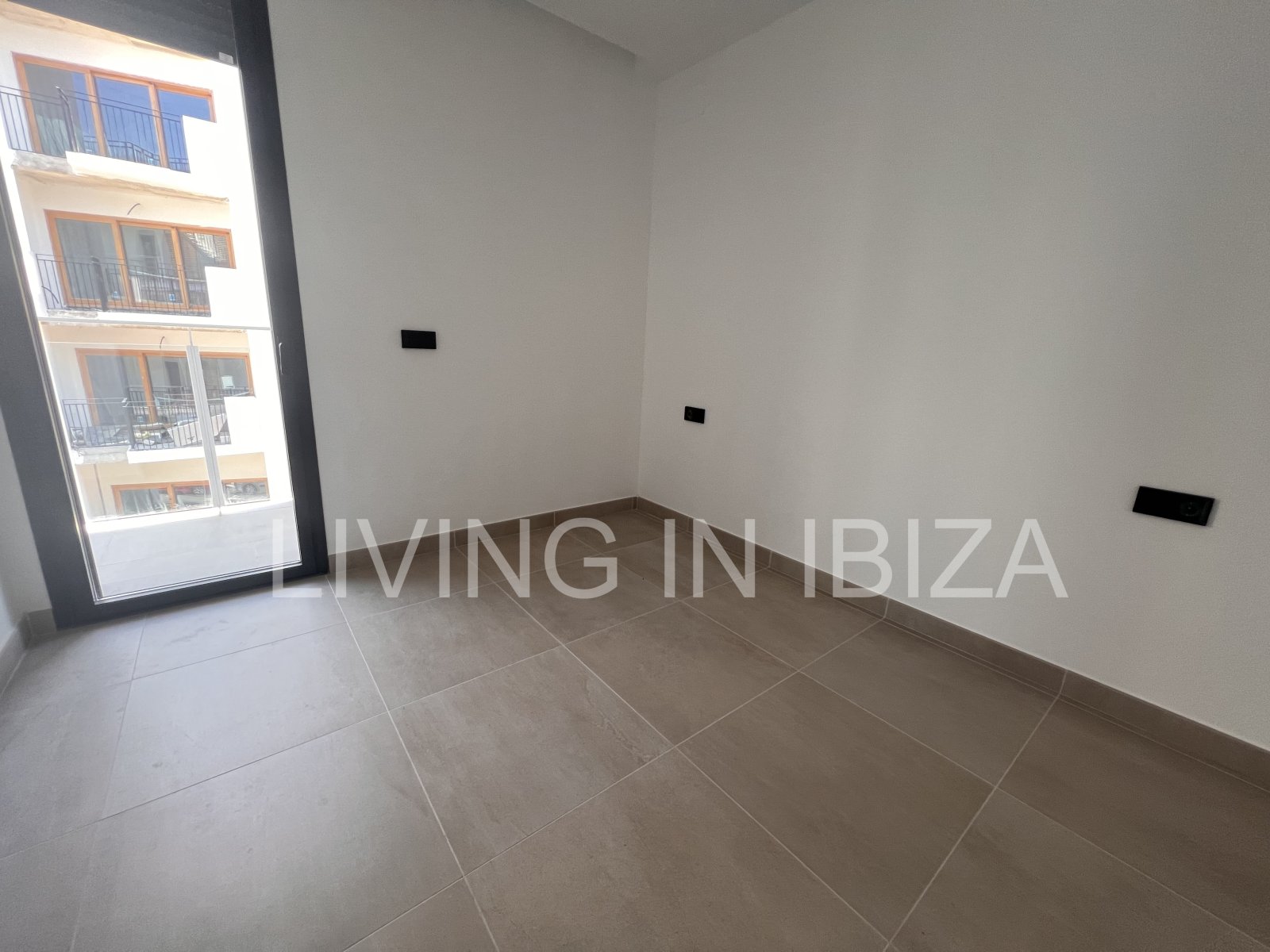 Annual rental. Available 15th July. Attractive and modern new unfurnished flat, with communal pool, parking, in Santa Eulalia, Ibiza.