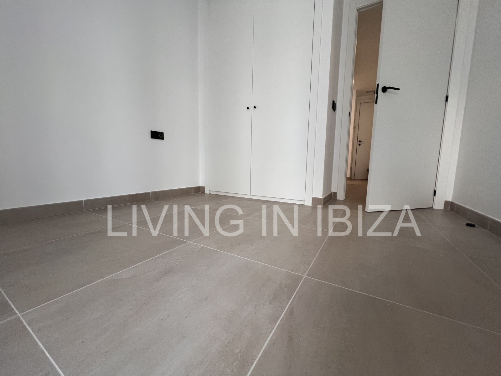 Annual rental. Available 15th July. Attractive and modern new unfurnished flat, with communal pool, parking, in Santa Eulalia, Ibiza.