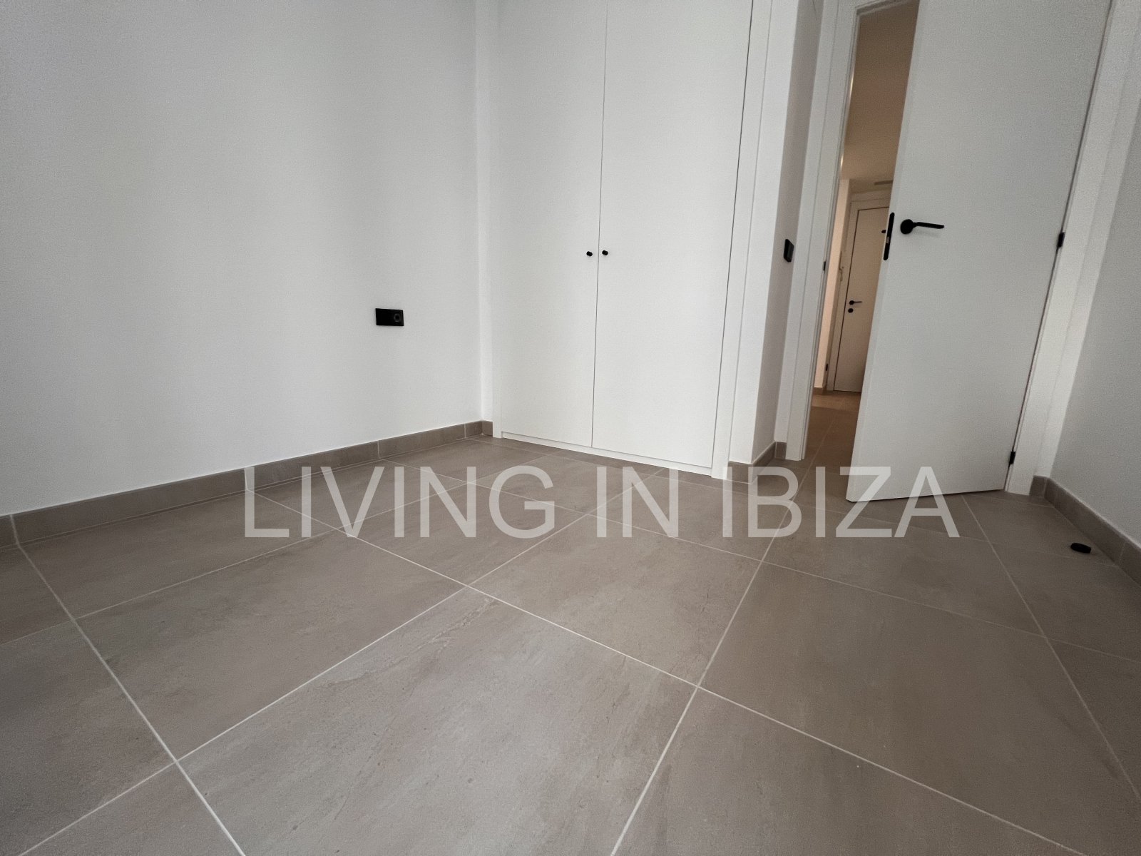 Annual rental. Available 15th July. Attractive and modern new unfurnished flat, with communal pool, parking, in Santa Eulalia, Ibiza.