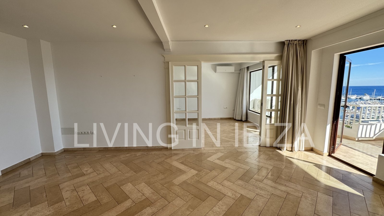 En primera línea, se alquila amplio piso sin muebles con vistas hacia el Puerto Deportivo de Santa Eulalia del Rio y el mar Mediterráneo.