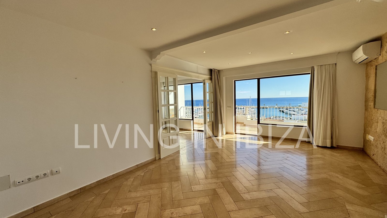 En primera línea, se alquila amplio piso sin muebles con vistas hacia el Puerto Deportivo de Santa Eulalia del Rio y el mar Mediterráneo.