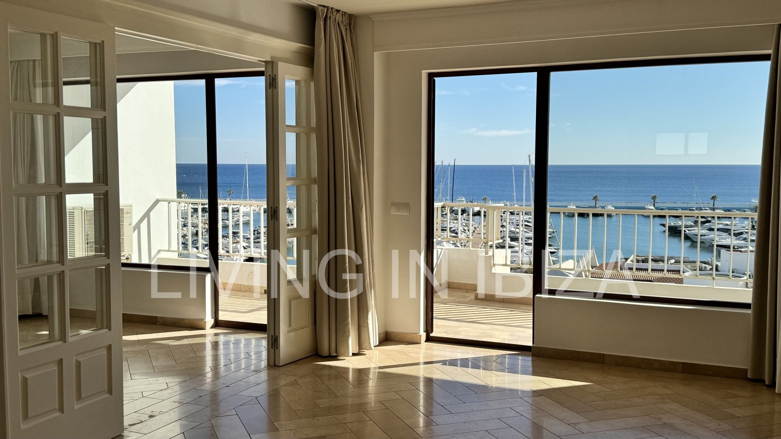 En primera línea, se alquila amplio piso sin muebles con vistas hacia el Puerto Deportivo de Santa Eulalia del Rio y el mar Mediterráneo.
